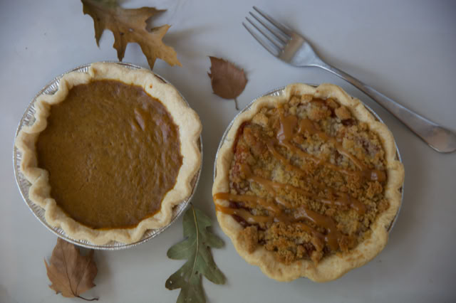 Two pumpkin pie tarts, one drizzled with caramel sauce.